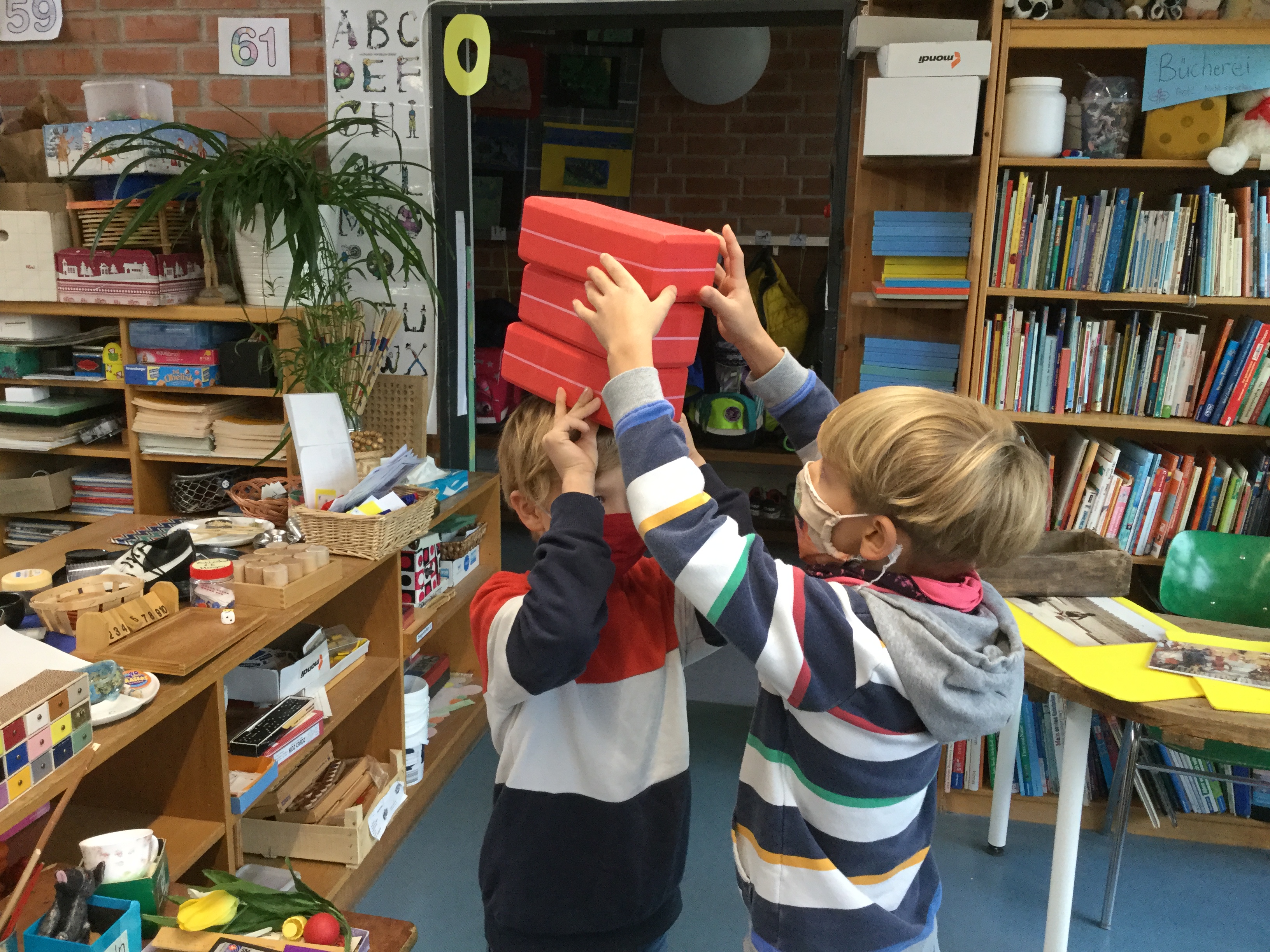 das kind trägt drei steine auf den kopf